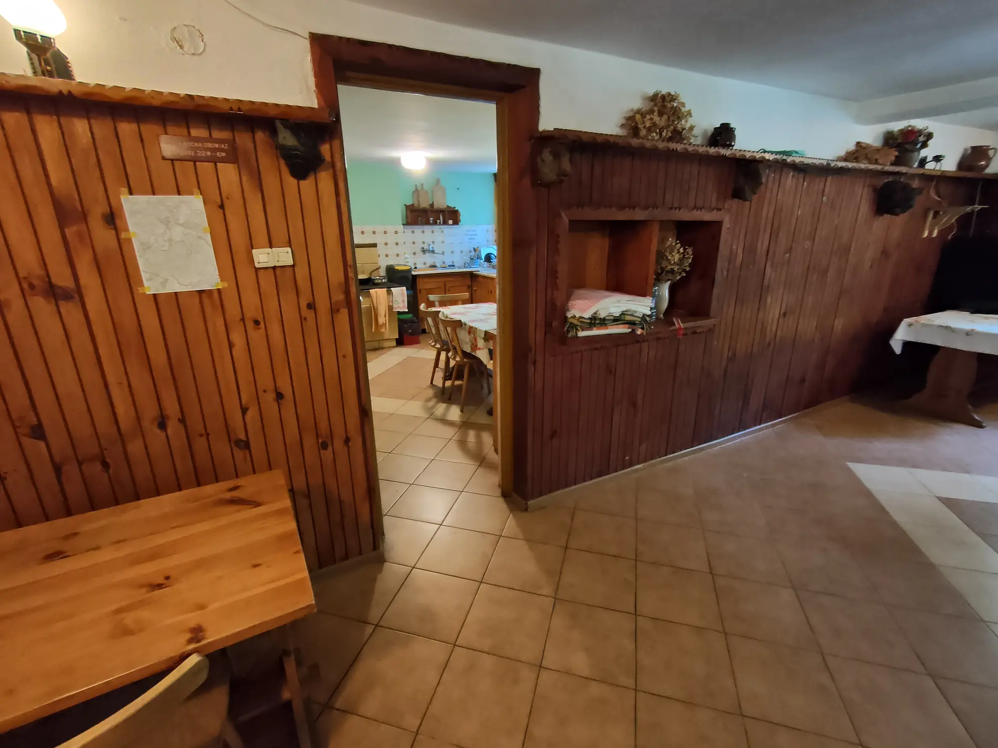 Korytarz z drewnianą boazerią prowadzący do aneksu kuchennego