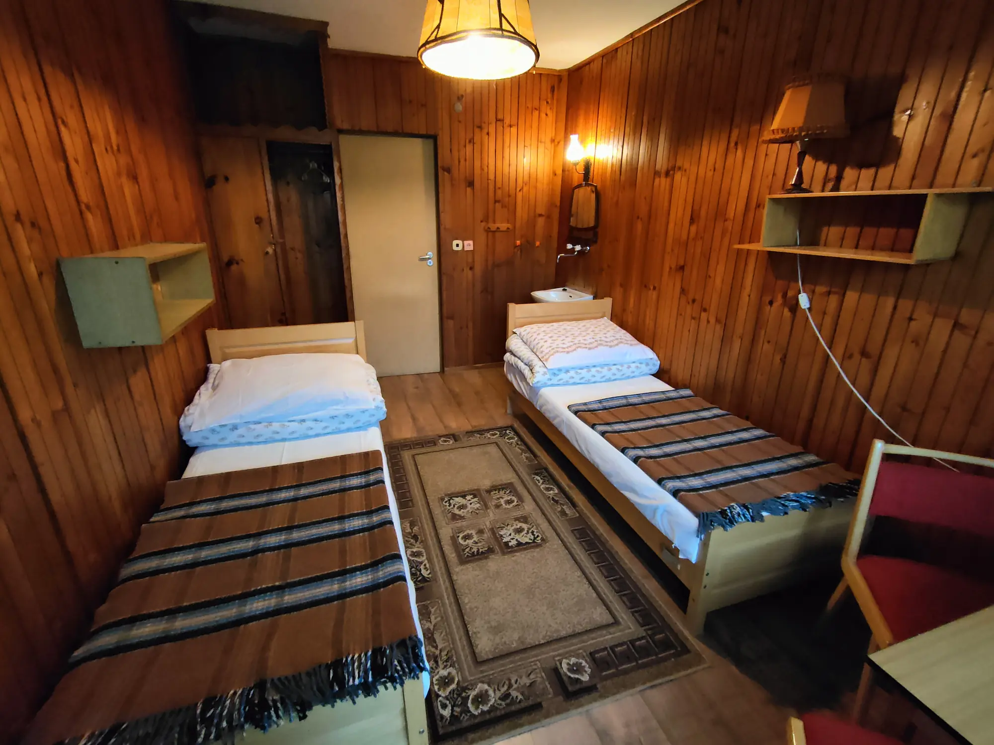 Pokój dwuosobowy z dwoma pojedynczymi łóżkami i drewnianą boazerią